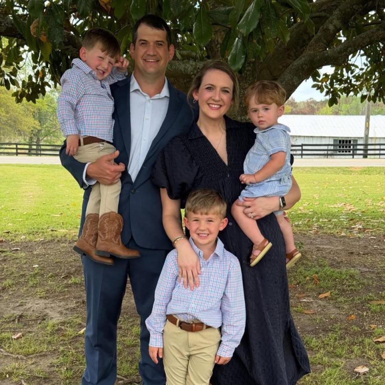Family of five posing outdoors under a large oak tree