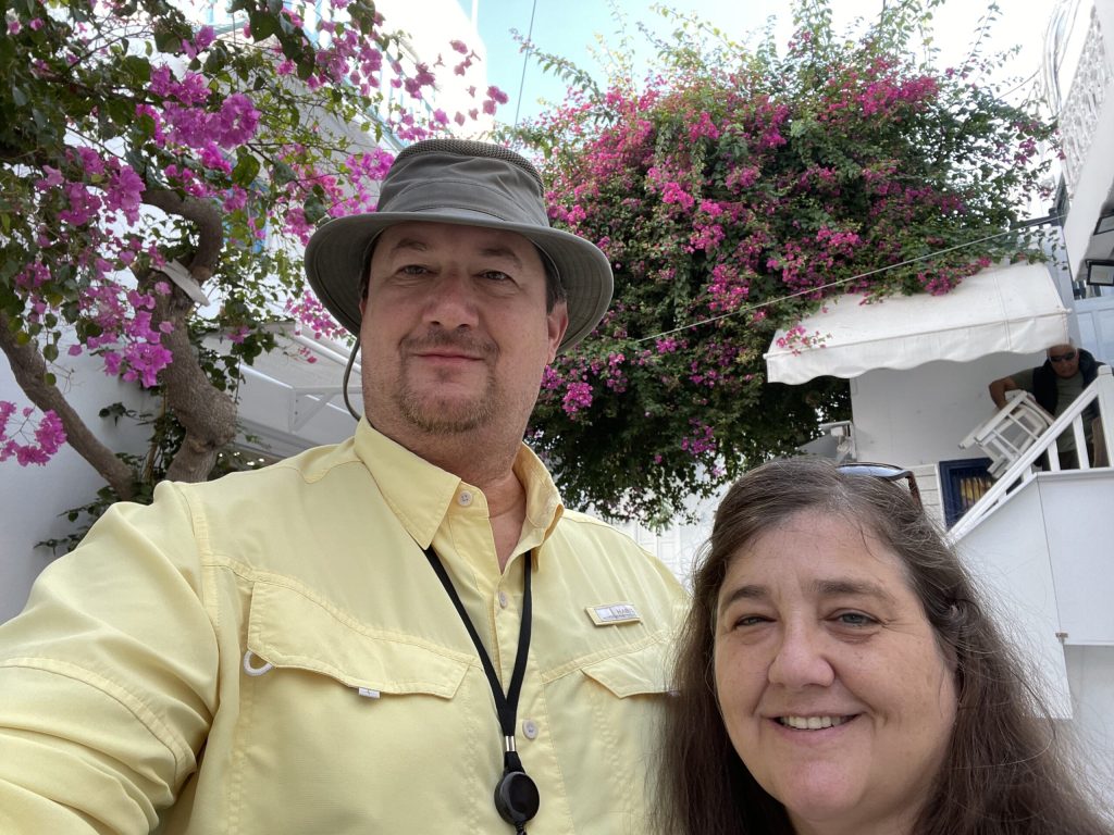 Couple under pink flowers on a white building